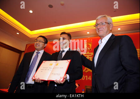 In Guangzhou, la Cina della provincia di Guangdong. 5 Novembre, 2014. Italia di Coppa del mondo vincendo il capitano Fabio Cannavaro (C), Italiano allenatore Marcello Lippi (R) e Vice Presidente del Gruppo Evergrande Liu Yongzhuo posano per una foto come Cannavaro tiene il suo contratto con Guangzhou Evergrande durante una conferenza stampa a Guangzhou, Cina del sud della provincia di Guangdong, nov. 5, 2014. Fabio Cannavaro è stato formalmente presentato come il nuovo allenatore di campioni cinese Guangzhou Evergrande. © Liu Dawei/Xinhua/Alamy Live News Foto Stock