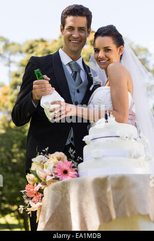 Felice sposa con bottiglia di champagne presso il park Foto Stock