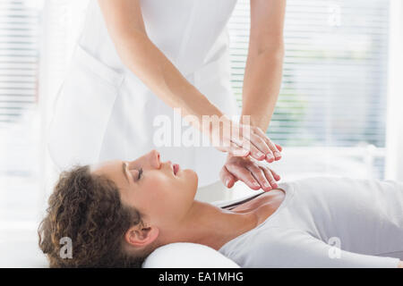 Terapista esegue Reiki su donna Foto Stock