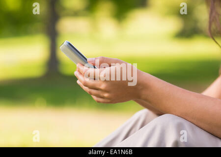 La sezione centrale della donna per la messaggistica di testo in posizione di parcheggio Foto Stock