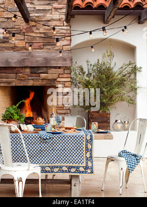 Sala da pranzo esterna scena con set table e fuoco