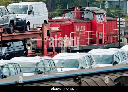 Un membro del personale della Deutsche Bahn AG (DB) salite su un treno diesel motore tra treni merci caricate con le vetture Volkswagen presso la stazione dei treni di Seelze, Germania, 05 novembre 2014. In Germania la Deutsche Bahn sta valutando la possibilità di lanciare azioni legali nei confronti dei macchinisti GDL unione come l'azienda ferroviaria bretelle in sé per il più lungo sciopero nei suoi 20 anni di storia. Lo sciopero annunciato il 04 novembre scatterà la condanna da entrambe le aziende e i leader politici. Sciopero sono previste azioni per ultimo da mercoledì 5 novembre a lunedì 10 novembre 2014. Foto: Julian Stratenschulte/dpa Foto Stock