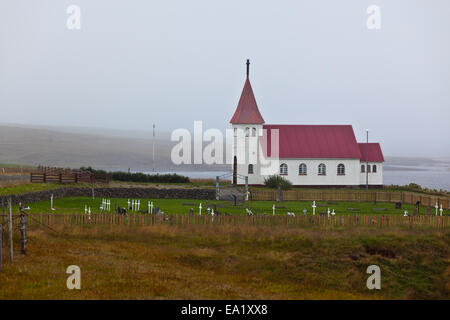 Tipica rurale chiesa islandese con cimitero locale a nuvoloso giorno Foto Stock