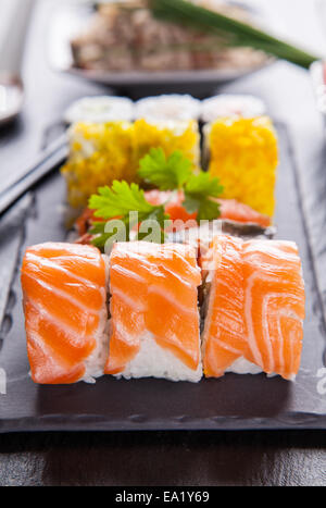 Vari tipi di sushi cibo servito su pietra nera Foto Stock