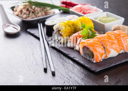 Vari tipi di sushi cibo servito su pietra nera Foto Stock