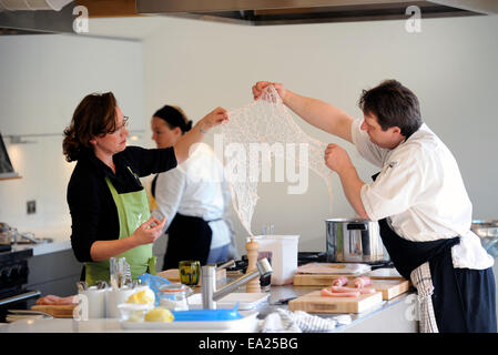 Utilizzando lobo grasso per avvolgere un piatto di pollo durante una scuola di cucina presso il timo a Southrop Manor Estate, GLOUCESTERSHIRE REGNO UNITO Foto Stock