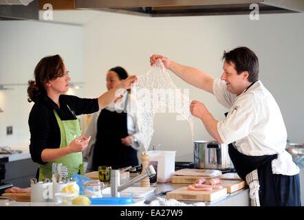 Utilizzando lobo grasso per avvolgere un piatto di pollo durante una scuola di cucina presso il timo a Southrop Manor Estate, GLOUCESTERSHIRE REGNO UNITO Foto Stock