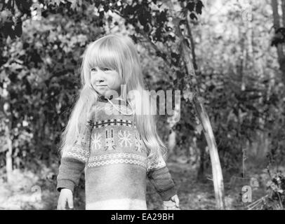 Close up Cute Kid femmina in autunno abbigliamento giacca a piedi a bosco. Catturate in monocromatico. Foto Stock