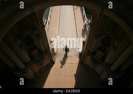 Un uomo cammina attraverso la Kronentor Gate, l'entrata principale per lo Zwinger posto a Dresda in Sassonia, Germania. Foto Stock