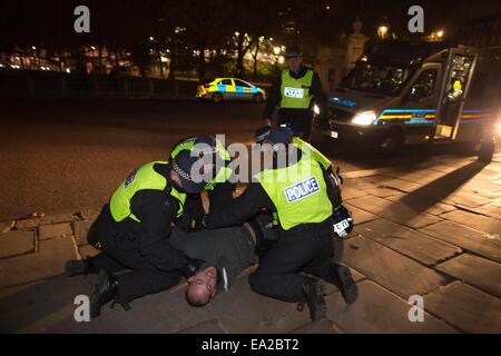 Londra, Regno Unito. 5 Novembre, 2014. La figura mostra un uomo arrestato su Hyde Park Corner come manifestanti corrono attraverso Londra parte degli attivisti anonimi group stage una "maschera illion marzo " a Londra REGNO UNITO. Credito: Jeff Gilbert/Alamy Live News Foto Stock