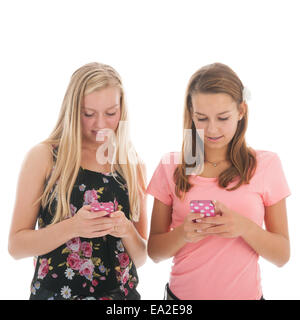 Due teenager ragazze con telefono cellulare isolato su sfondo bianco Foto Stock