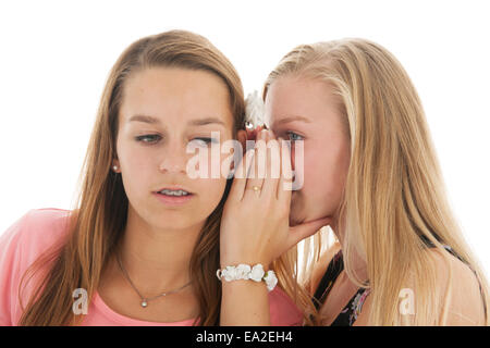Le ragazze adolescenti sono whispering gossip a ciascun altro Foto Stock