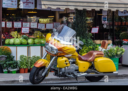 Giallo personalizzato moto parcheggiata di fronte mercato. Foto Stock
