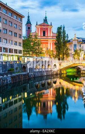 Lubiana triple bridge e chiesa francescana dell'Annunciazione si riflette nel fiume Ljubljanica di notte, Lubiana, Slovenia Foto Stock