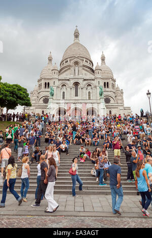 Parigi, Francia - 09 agosto 2014: folla di turisti a piedi vicino al Sacre Coeur basilica nel giorno di estate, grande cattedrale medievale, Ba Foto Stock