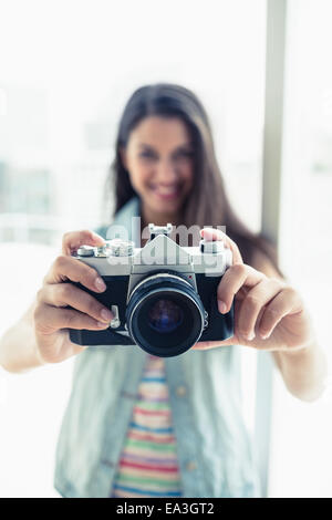 Felice giovane donna prendendo una foto con la fotocamera Foto Stock