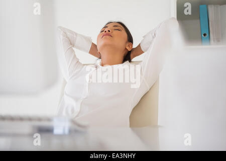 Casual imprenditrice napping alla sua scrivania Foto Stock