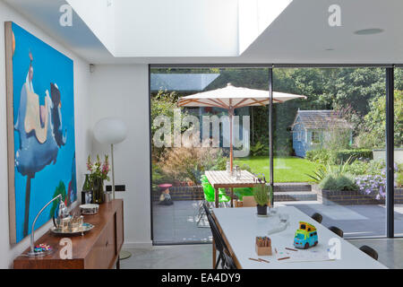 Estensione da cucina con lucernario con vista al giardino in moderno London casa di famiglia, UK. Foto Stock