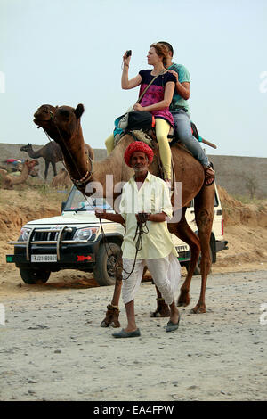 Cameraman, Turbante, camel, turistico, stranieri, femmina, Canon DSLR, tiro, in Pushkar, Rajasthan, India. Foto Stock