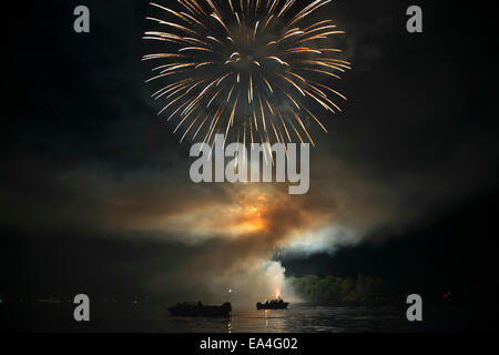 Fuochi d'artificio sul lago illuminando le barche in acqua; Kenora, Ontario, Canada Foto Stock