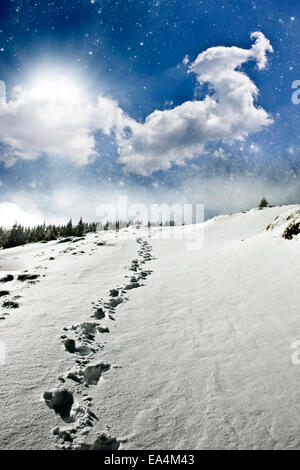 Sentiero innevato sul fianco di una collina e bella abtract del cielo della sera Foto Stock