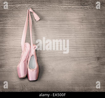 Nuova rosa scarpe da ballo appesi su sfondo di legno.in stile vintage. Foto Stock