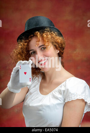 Ragazza sorridente con ace su uno sfondo rosso Foto Stock