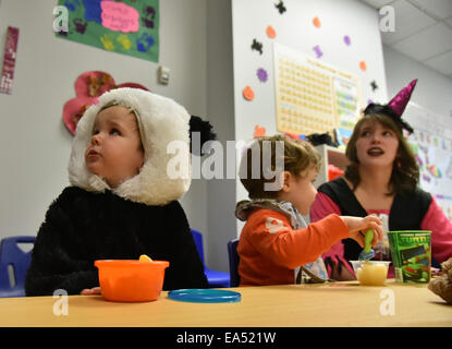 Bambini in età prescolare con il loro insegnante in costume nella loro classe kindergarten di halloween Foto Stock