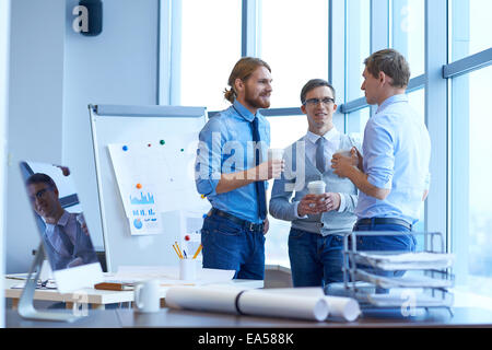 Un gruppo di giovani imprenditori per discutere di nuove idee e strategie in ufficio Foto Stock