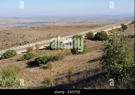 La recinzione di confine tra Israele e la Siria come si vede da una collina sulle alture del Golan in Israele Foto Stock