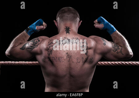 Vista posteriore di un Boxer che flette i muscoli in un anello di boxe Foto Stock