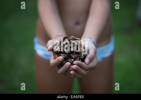 Ragazza in bikini con un pinecone, Bova Marina, Calabria, Italia Foto Stock