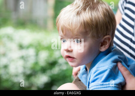 Ragazzo seduto sulla madre di giro Foto Stock