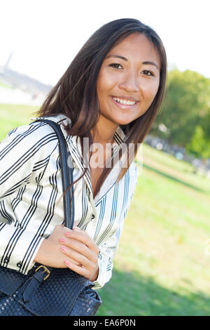 Allegro ragazza asiatica a camminare in un parco Foto Stock