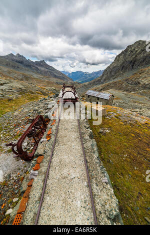 Vecchio e danneggiato ferrovia via utilizzato nelle alpi italiane ad alta quota della costruzione della diga, materiale di trasporto o mining pu Foto Stock