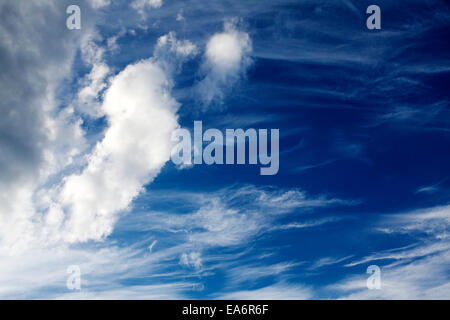 Cirrus e cumuli di nuvole contro un cielo blu scuro. Foto Stock