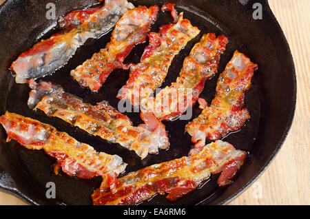 Bacon cotto rashers su una padella. Messa a fuoco selettiva Foto Stock