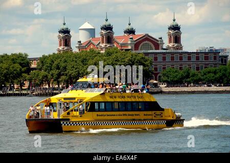 New York: New York Water Taxi sul fiume Hudson passando da Ellis Island National Historic Park Foto Stock