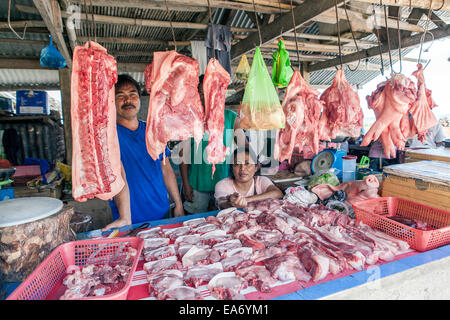 Una famiglia Filippini vende carni suine fresche di loro in stallo presso il locale mercato degli agricoltori in città Dimiao, Isola di Bohol, Filippine. Foto Stock