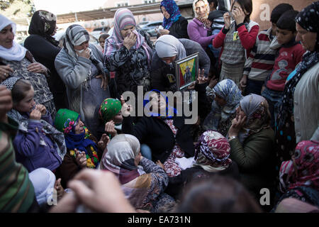 Suruc, Turchia. 07 Nov, 2014. Una donna che piange come lei si mantiene un ritratto di suo figlio, un popolo curdo è Unità di Protezione (YPG) combattente che morì durante i combattimenti in assediato frontiera siriana città di Kobane. Funerali di YPG e YPJ fighters in Suruc, Turchia il 7 novembre 2014. Credito: Konstantinos Tsakalidis/Alamy Live News Foto Stock