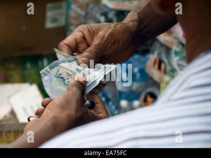 Georgetown, GUYANA. 7 Nov, 2014. 07 Novembre, 2014. Guyana dollari cambiare le mani alla Stabroek mercato nel cuore di Georgetown, Guyana. Essa è il principale mercato in città in corrispondenza della giunzione delle banchine e il minibus terminale. A base di pesce e di carne, frutta e verdura e di tutti i tipi di casa tenere le merci sono disponibili dalla i produttori sia al coperto che all'aperto. © Ralph Lauer/ZUMA filo/Alamy Live News Foto Stock