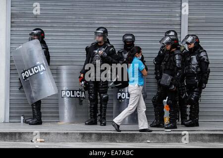 Bogotà, Colombia. 7 Nov, 2014. Un residente passeggiate nella parte anteriore dei poliziotti durante i disordini in Università pedagogica di Bogotà, a Bogotà, capitale della Colombia, su nov. 7, 2014. Secondo la stampa locale, diverse persone con cappuccio rioted nell'Università pedagogica di Bogotà, che ha portato a cinque feriti, tra loro due poliziotti con ustioni, due studenti e una guardia di sicurezza dell'università. © Jhon Paz/Xinhua/Alamy Live News Foto Stock