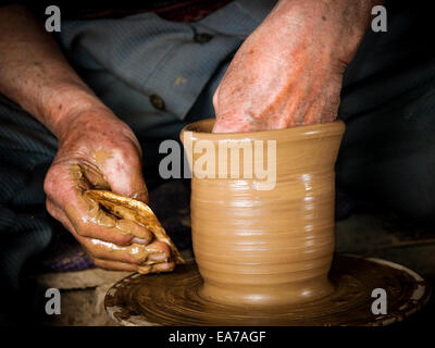 Le mani di un vasaio, creazione di un vaso di terracotta sul cerchio Foto Stock