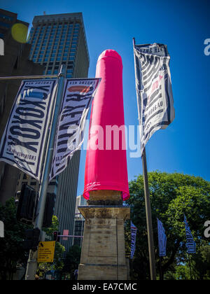 Sydney, Australia. 8 Novembre, 2014.L'Obelisco a Hyde Park avvolti in un 18m preservativo rosa è mostrato con i banner pubblicitari per promuovere la consapevolezza dell'HIV. Credito: MediaServicesAP/Alamy Live News Foto Stock