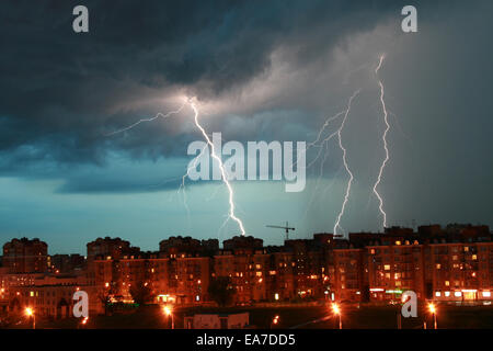 Lightning over night city durante un temporale Foto Stock