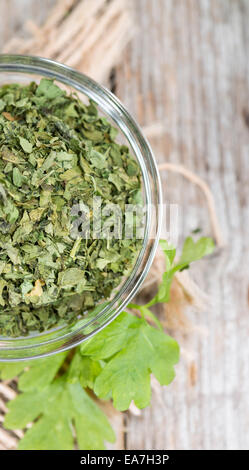 Porzione di prezzemolo essiccato su vintage sfondo di legno Foto Stock