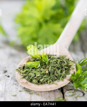 Porzione di prezzemolo essiccato su vintage sfondo di legno Foto Stock