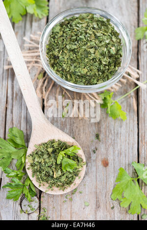 Porzione di prezzemolo essiccato su vintage sfondo di legno Foto Stock
