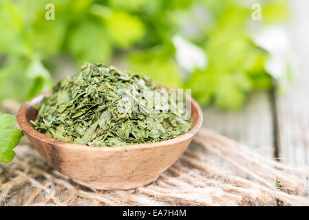 Porzione di prezzemolo essiccato su vintage sfondo di legno Foto Stock