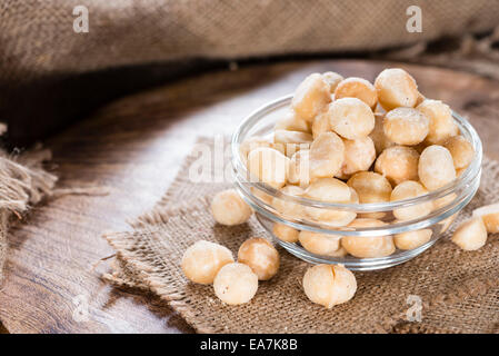 Porzione di noci di Macadamia (tostati e salati) su sfondo di legno Foto Stock